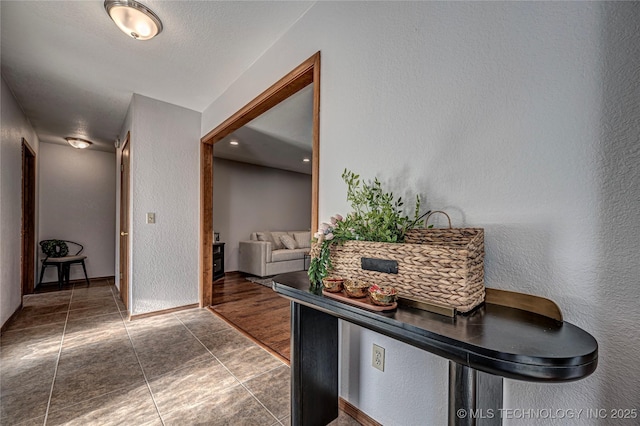 hallway with tile patterned flooring and a textured wall