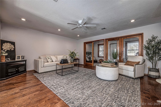 living area featuring recessed lighting, visible vents, and hardwood / wood-style flooring