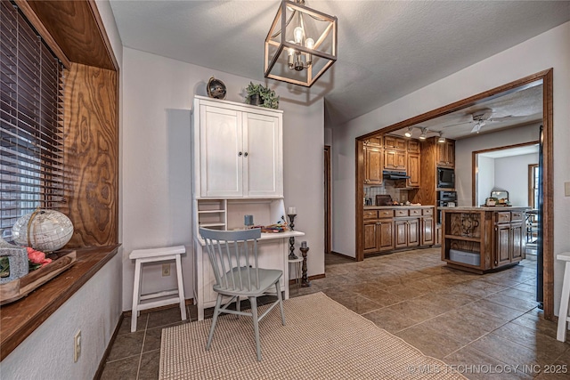 office featuring ceiling fan with notable chandelier, baseboards, and a textured ceiling