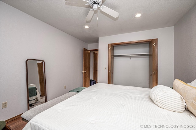 bedroom featuring a closet, a textured ceiling, wood finished floors, and a ceiling fan