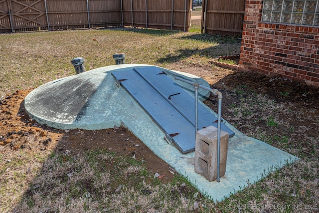 entry to storm shelter featuring a yard