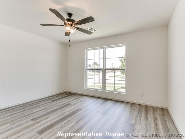 spare room featuring visible vents, baseboards, light wood-style flooring, and a ceiling fan