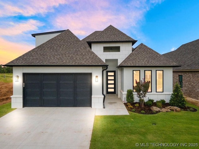 view of front of home featuring driveway, a front yard, roof with shingles, and an attached garage