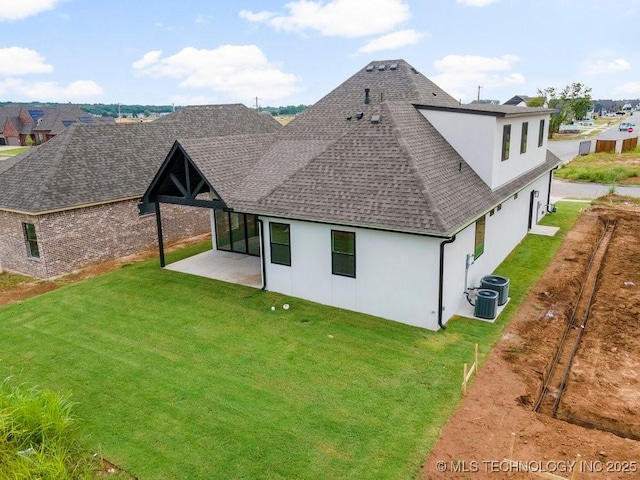 rear view of house with a shingled roof, central air condition unit, stucco siding, a yard, and a patio area