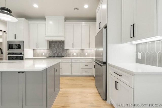 kitchen featuring tasteful backsplash, appliances with stainless steel finishes, and light countertops