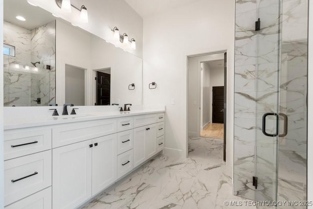 bathroom with double vanity, marble finish floor, a marble finish shower, and a sink