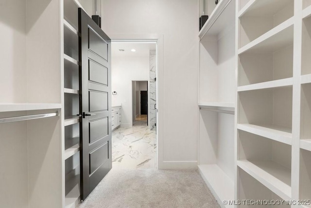 spacious closet featuring marble finish floor and carpet floors