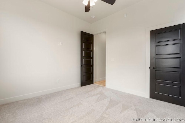 carpeted empty room with baseboards and ceiling fan