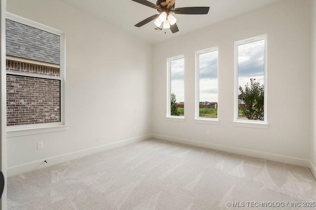 carpeted empty room with baseboards and ceiling fan