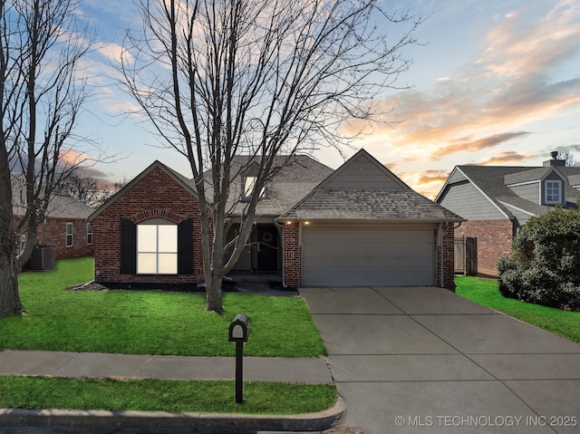 view of front of home featuring driveway, a front lawn, an attached garage, brick siding, and central AC unit