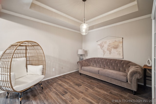 living area featuring baseboards, a raised ceiling, wood finished floors, and crown molding