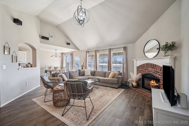 living area with visible vents, dark wood-style floors, a chandelier, and a fireplace