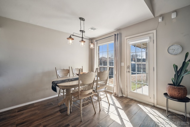 dining space with visible vents, baseboards, and wood finished floors