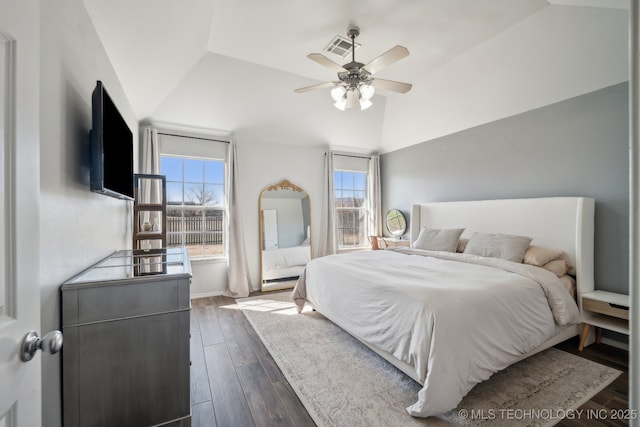 bedroom featuring a ceiling fan, lofted ceiling, visible vents, and dark wood-style flooring