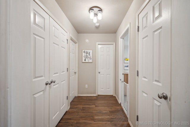 hall with dark wood finished floors and baseboards