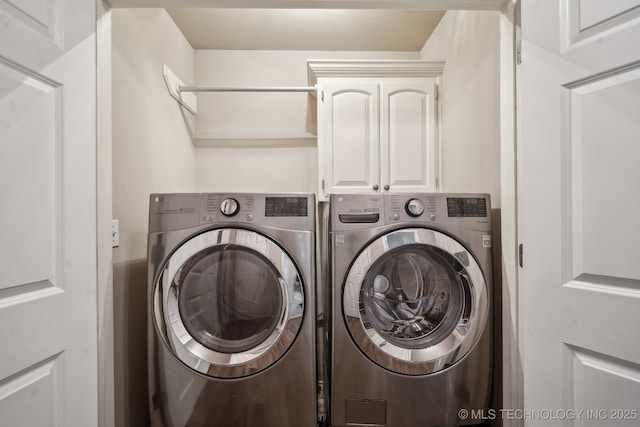 laundry room featuring washing machine and clothes dryer and cabinet space