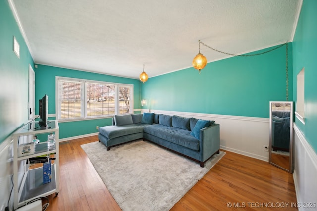 2503 S Pittsburg Ave, Tulsa, OK 74114 - living area featuring a textured ceiling, wood finished floors, and wainscoting
