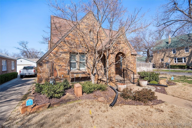 tudor home featuring stone siding