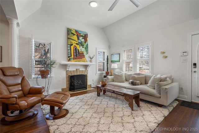 living room featuring wood finished floors, baseboards, lofted ceiling, ceiling fan, and a tiled fireplace