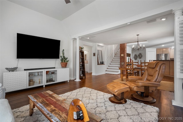 living area with a notable chandelier, wood finished floors, stairway, decorative columns, and baseboards