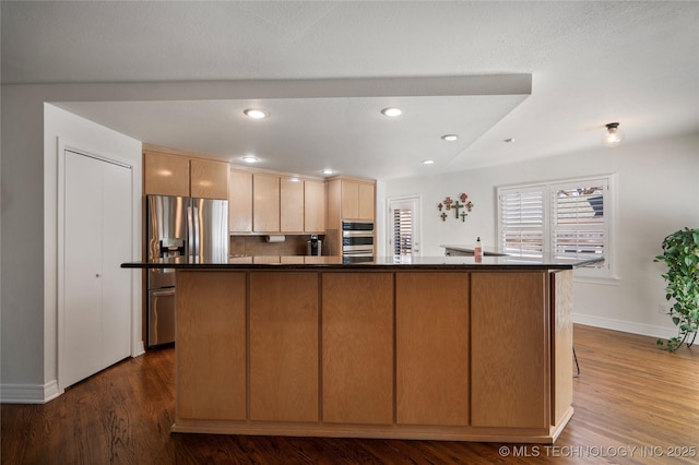 kitchen with baseboards, recessed lighting, dark wood-style flooring, appliances with stainless steel finishes, and dark countertops