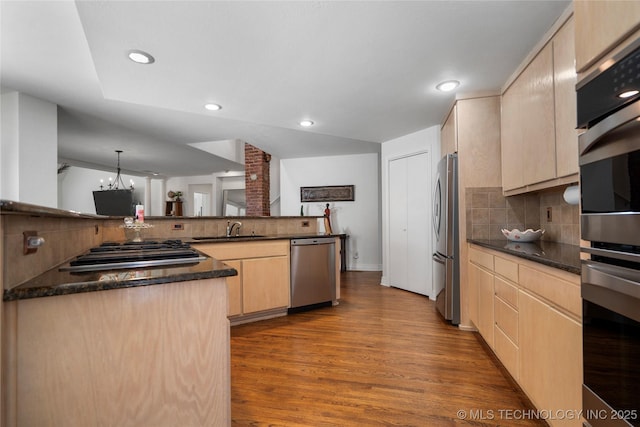 kitchen featuring dark wood-type flooring, light brown cabinets, a sink, tasteful backsplash, and stainless steel appliances