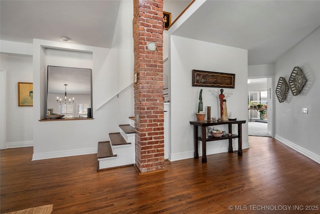 staircase with a chandelier, baseboards, a healthy amount of sunlight, and wood finished floors