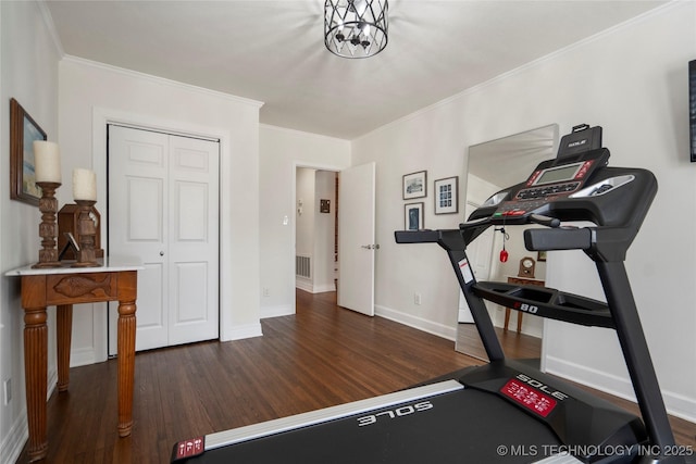 workout room with dark wood-type flooring, baseboards, and ornamental molding