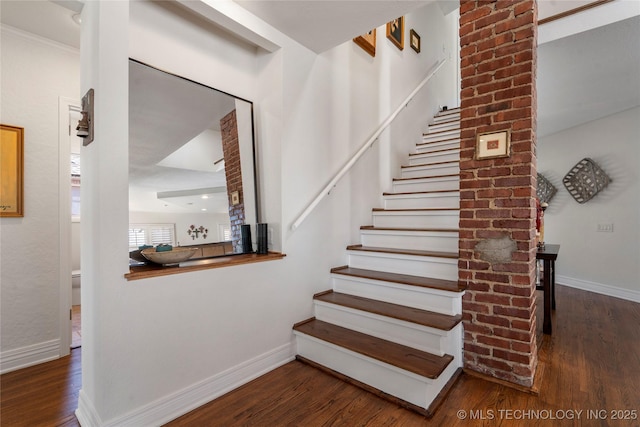 staircase featuring wood finished floors and baseboards