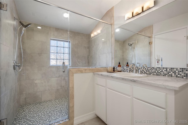 full bath with backsplash, a stall shower, and vanity