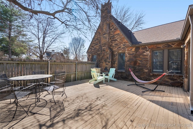 wooden terrace featuring outdoor dining space and fence