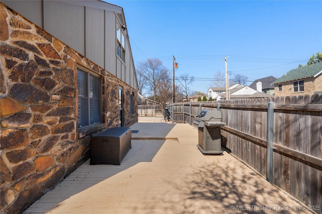 view of patio featuring a grill and fence