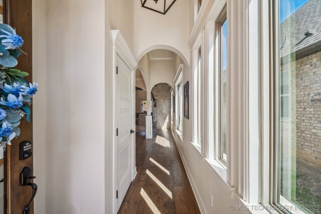 3828 W Orlando St, Broken Arrow, OK 74011 - corridor featuring arched walkways, dark wood finished floors, and a towering ceiling