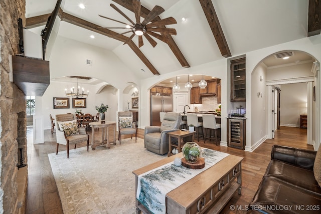 3828 W Orlando St, Broken Arrow, OK 74011 - living room featuring a ceiling fan, beverage cooler, high vaulted ceiling, arched walkways, and wood finished floors