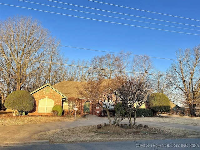 view of front of property featuring brick siding and a shingled roof