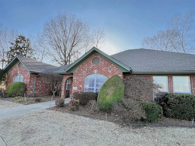 view of front of house featuring brick siding and a shingled roof