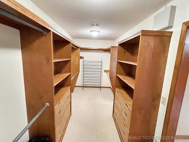 walk in closet featuring light colored carpet and visible vents