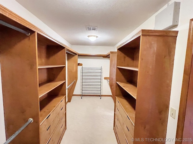 spacious closet with visible vents and light colored carpet