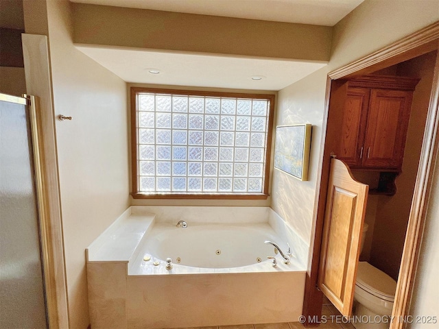 bathroom with a stall shower, toilet, and a whirlpool tub