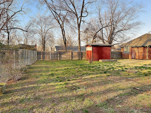 view of yard with a storage shed, an outbuilding, and a fenced backyard