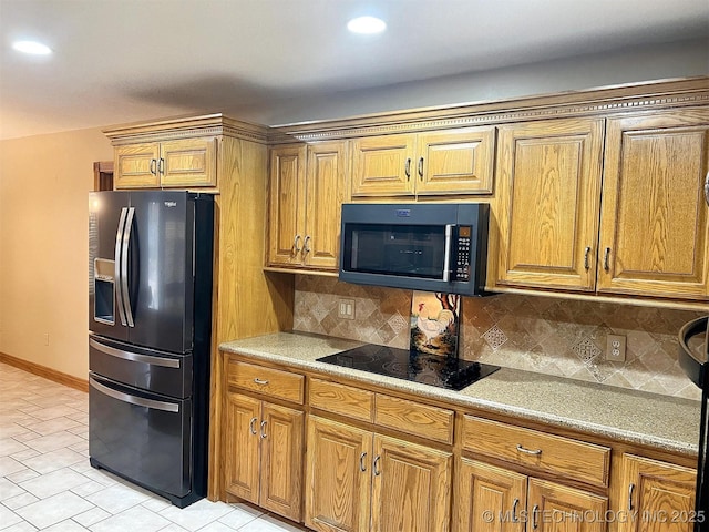 kitchen with black appliances, brown cabinetry, and backsplash