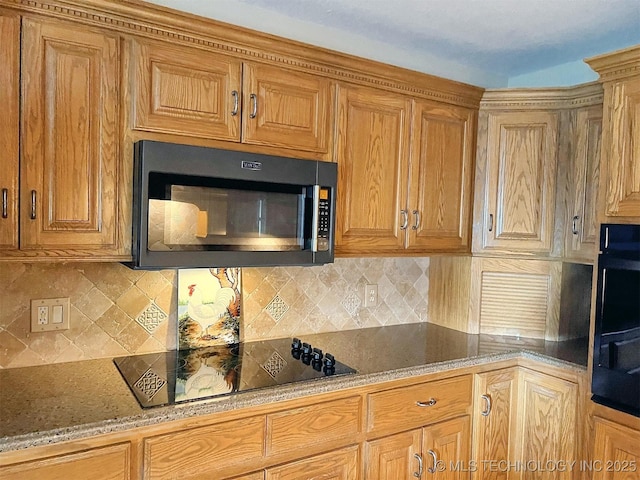 kitchen with stone counters, black electric stovetop, backsplash, and brown cabinets