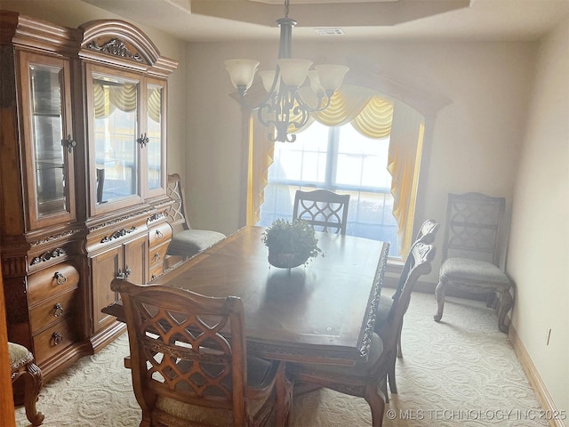 dining space with baseboards and a notable chandelier