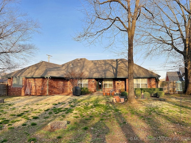 view of front of house featuring brick siding, a patio area, and fence