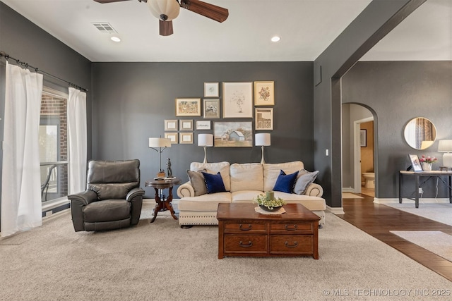 living area with a ceiling fan, recessed lighting, visible vents, and arched walkways