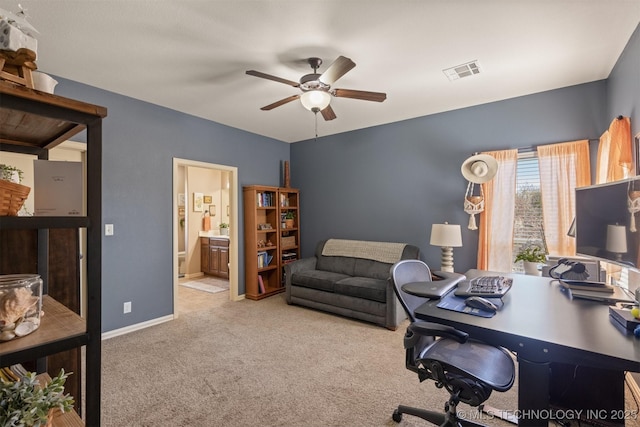 carpeted office featuring visible vents, baseboards, and ceiling fan