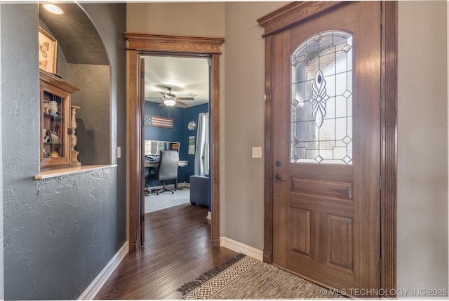 entryway featuring dark wood finished floors, ceiling fan, and baseboards