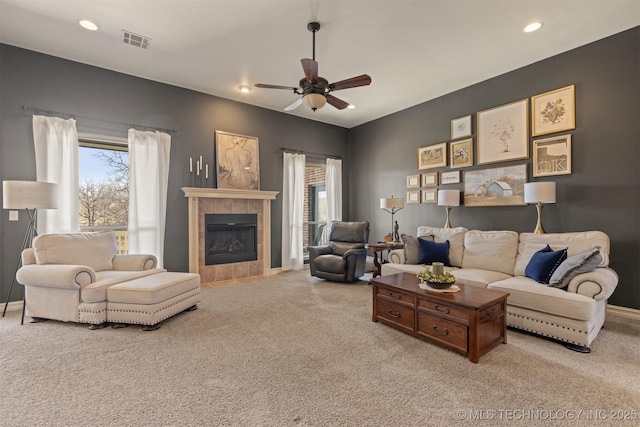 carpeted living area featuring visible vents, recessed lighting, a fireplace, baseboards, and ceiling fan