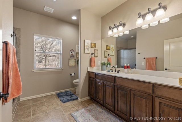 bathroom with visible vents, toilet, a shower stall, baseboards, and vanity