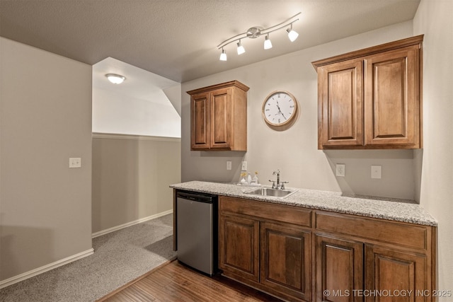 kitchen with a sink, baseboards, dishwashing machine, a textured ceiling, and dark wood-style flooring